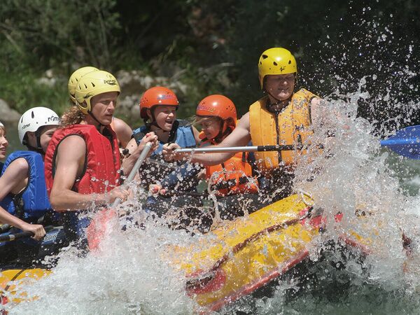 Freundesgruppe im Wildwasser beim Rafting