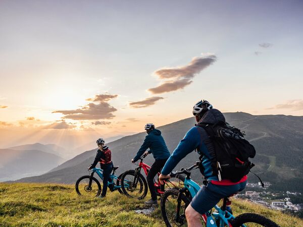 3 Radfahrer bei Sonnenaufgang auf dem Berg